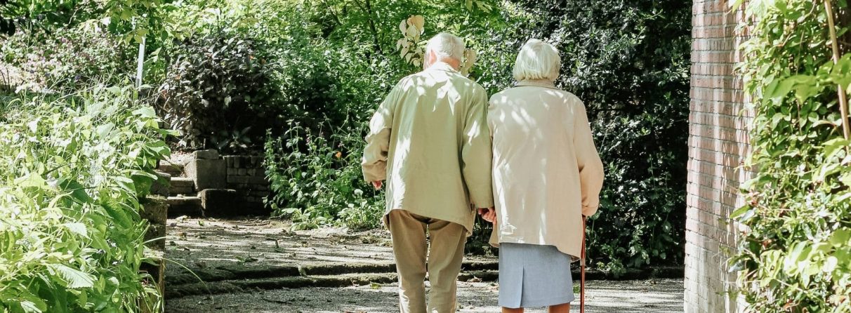 elderly people walking arm in arm