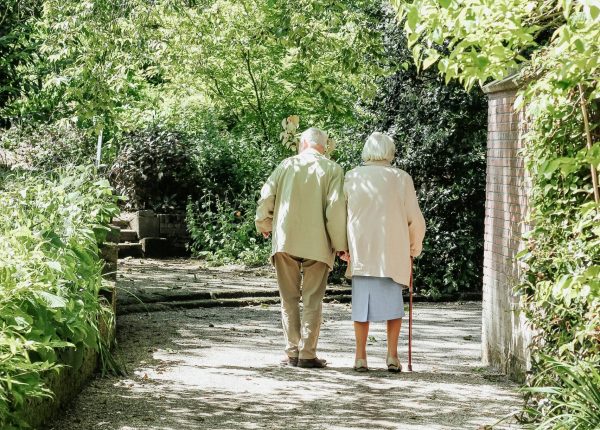 elderly people walking arm in arm